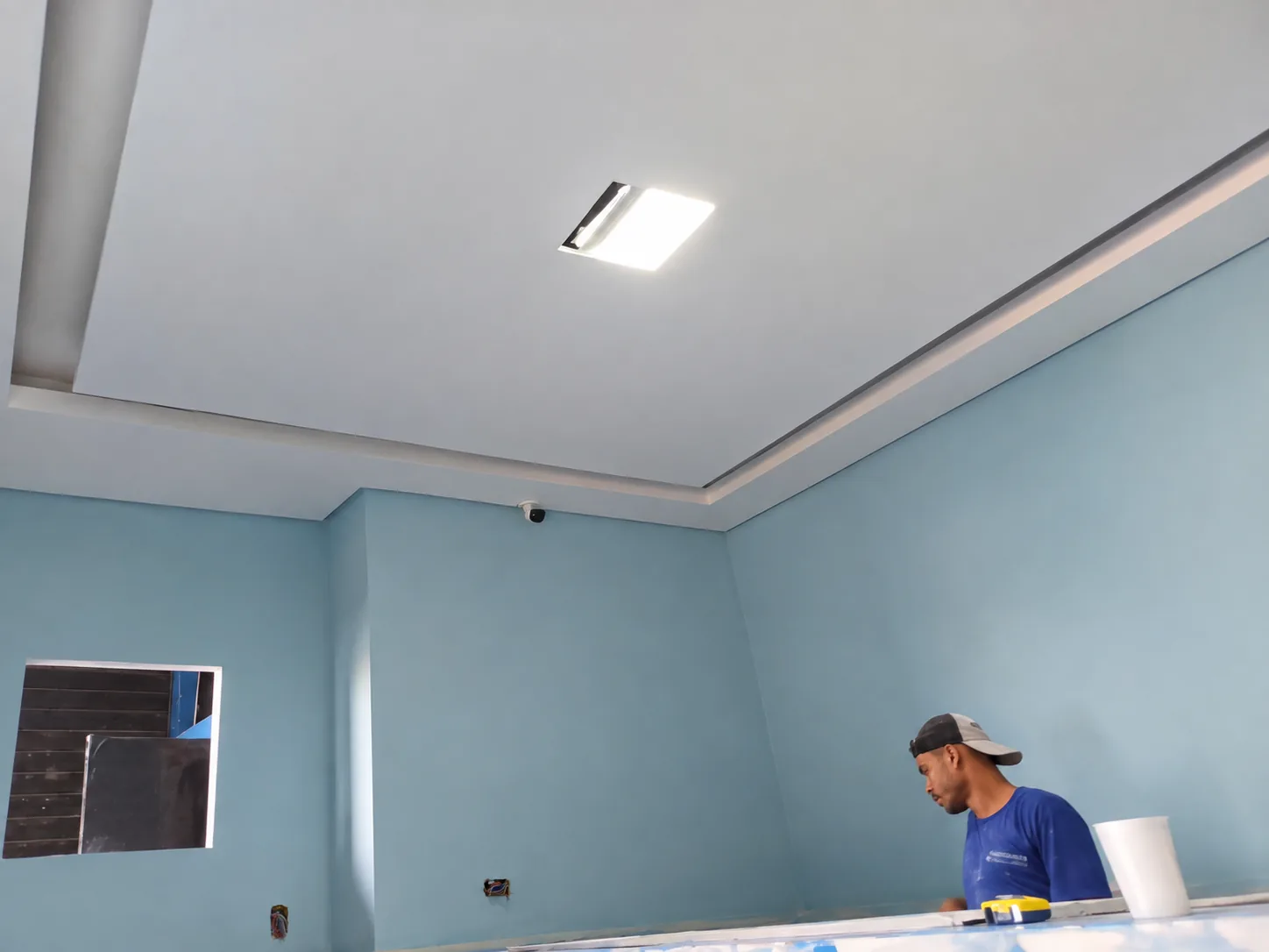 Profissional trabalhando em acabamento de gesso na obra